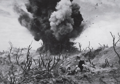 In a picture that captures the violence and sheer destruction inherent in war perhaps more graphically than any other ever published in LIFE, Marines take cover on an Iwo Jima hillside amid the burned-out remains of banyan jungle, as a Japanese bunker is obliterated in March 1945.